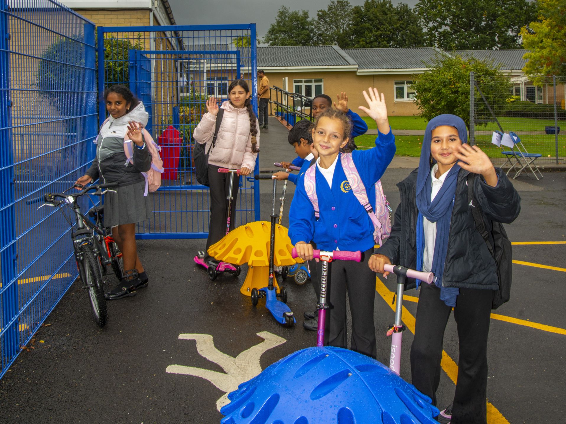 Primary school children with scooters and bikes