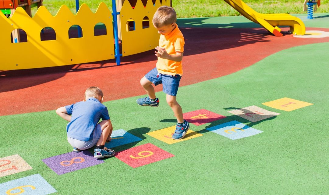 2 children playing hopscotch
