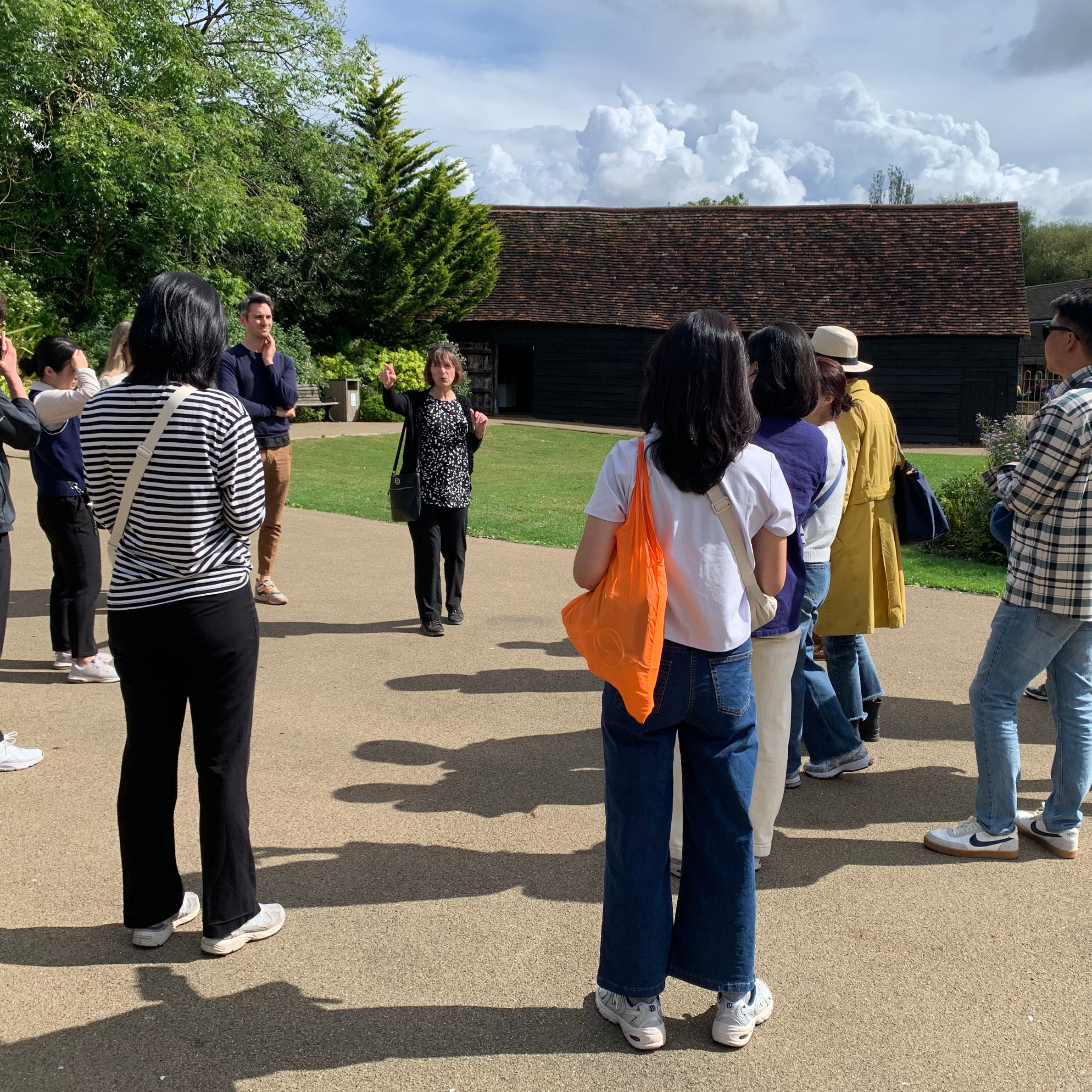 people stood in the courtyard of Headstone Manor and Museum, listening to a tour guide lead the tuesday tour
