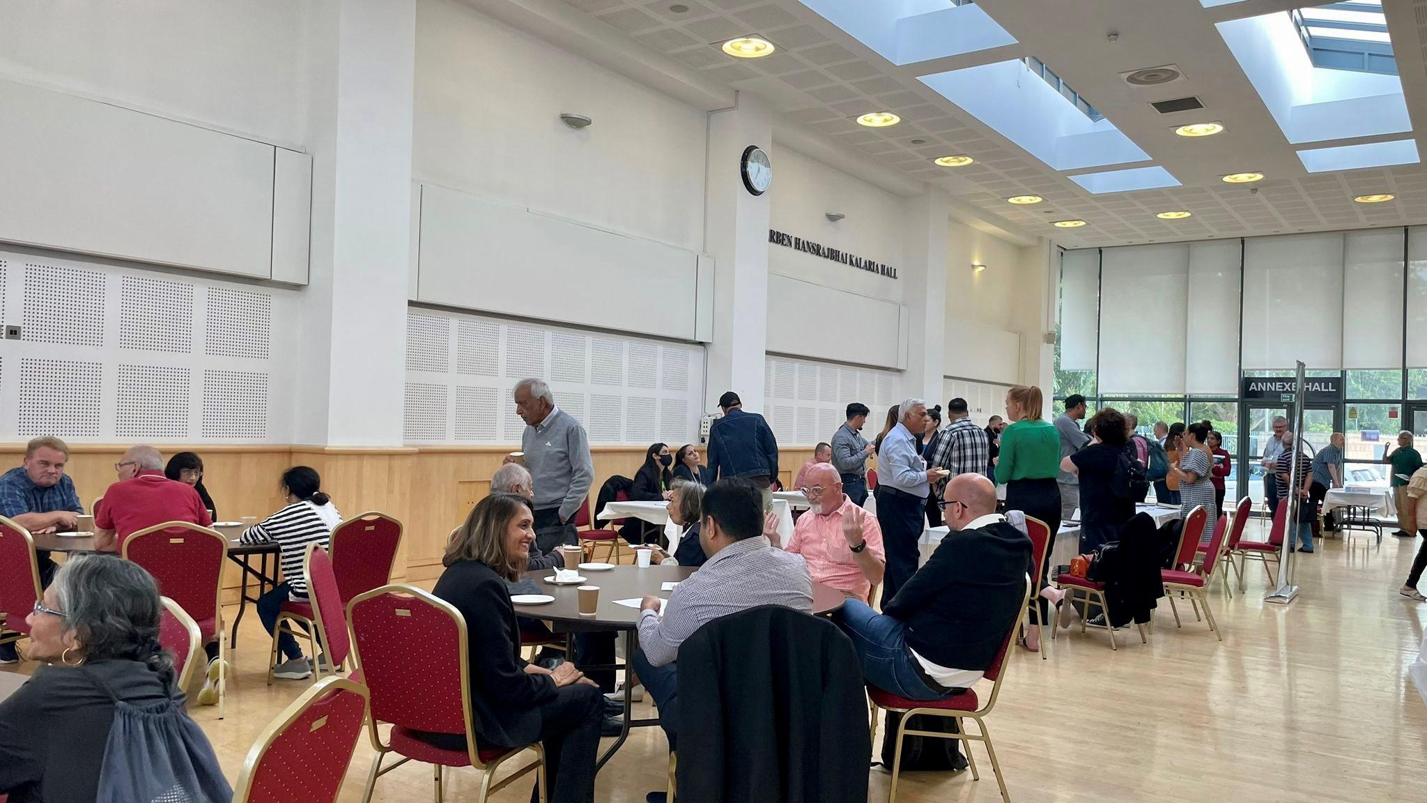 Hall with people talking over coffee