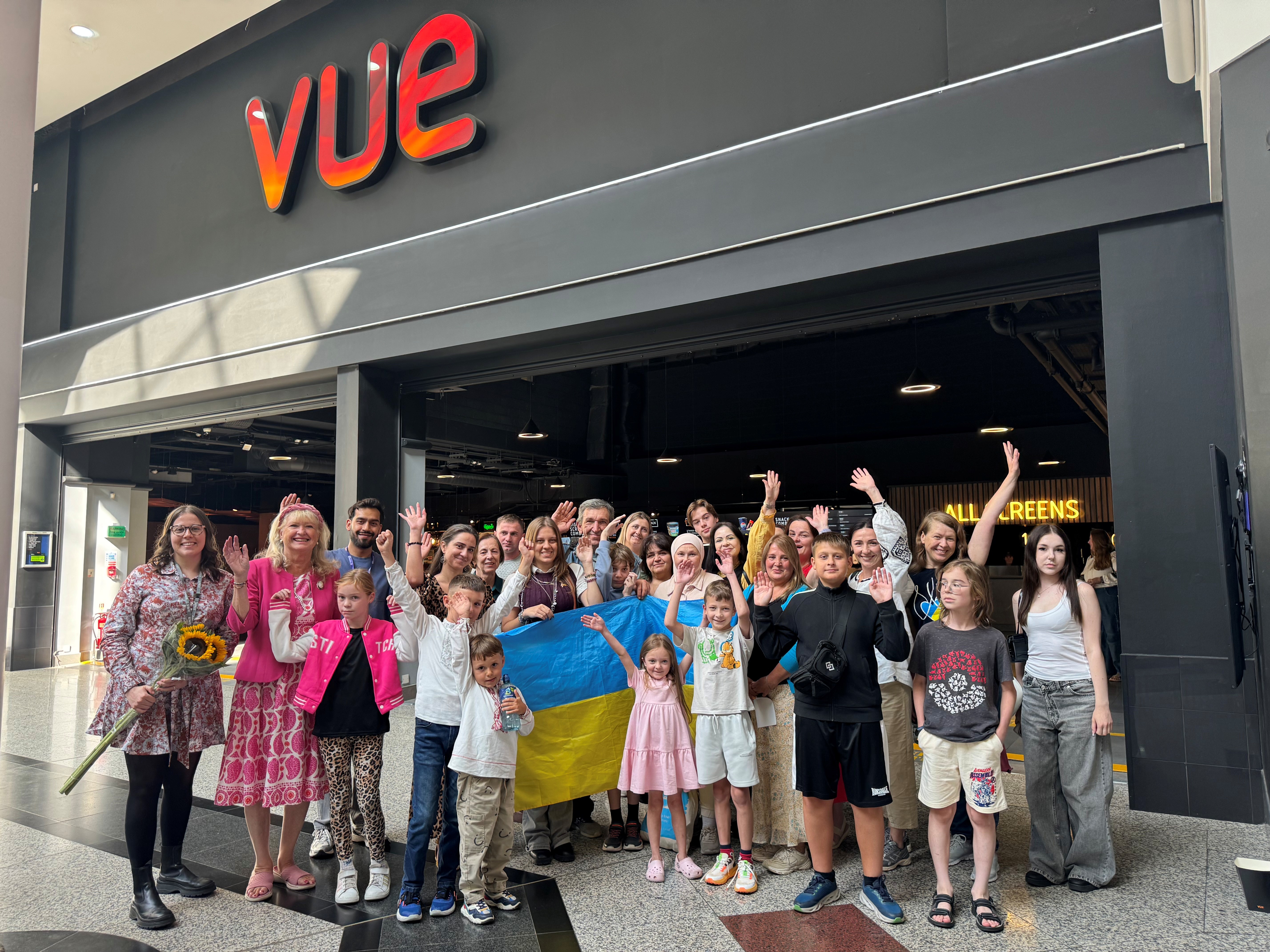 Group of people holding the Ukrainian flag outside Harrow Vue cinema